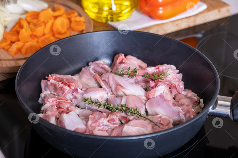 Скачать Кусочки рубленого мяса кролика тушатся на домашней плите в сковороде с антипригарным покрытием фотосток Ozero