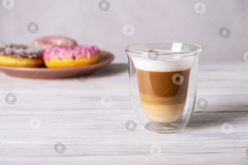 Скачать Глазированные украшенные пончики на тарелках и кофе латте или капучино фотосток Ozero