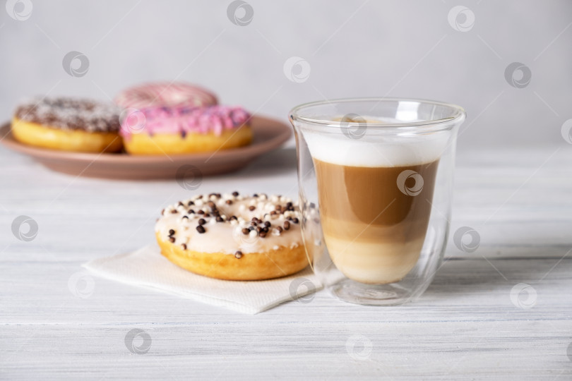 Скачать Глазированные украшенные пончики на тарелках и кофе латте или капучино фотосток Ozero