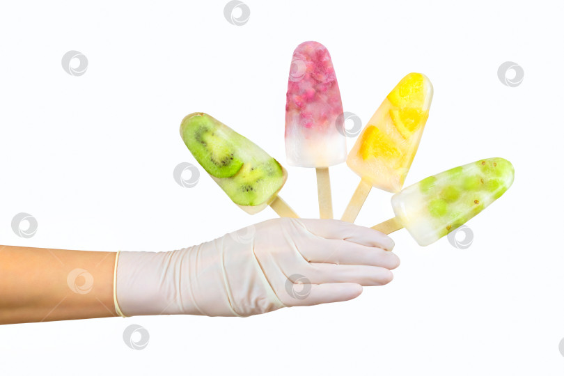 Скачать Рука в перчатке держит четыре фруктовых мороженых. Концепция летнего сезона фотосток Ozero