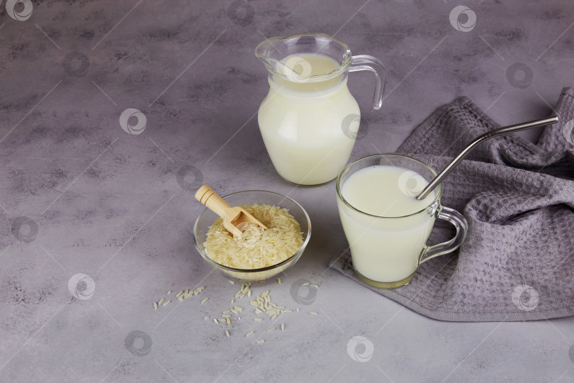 Скачать Рисовое молоко в стеклянной кружке и кувшине на темно-сером фоне. фотосток Ozero
