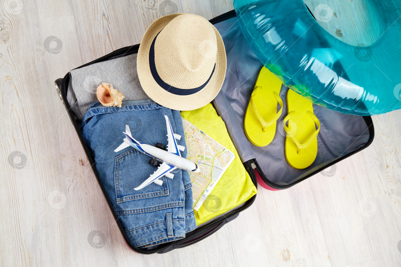 Скачать Открытый чемодан с одеждой и аксессуарами для отдыха на море. фотосток Ozero