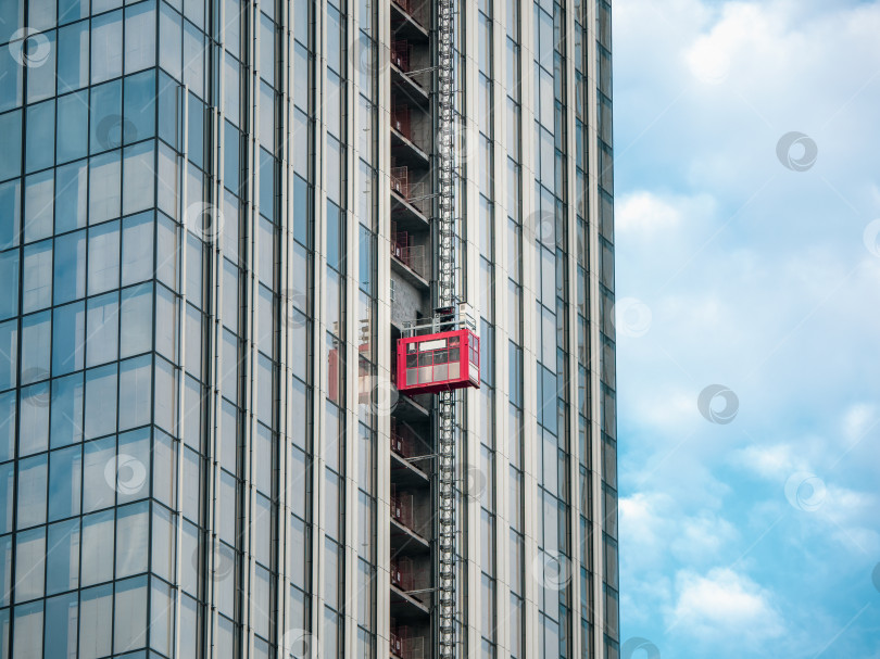 Скачать Лифты поднимают на строительные площадки строящегося небоскреба фотосток Ozero