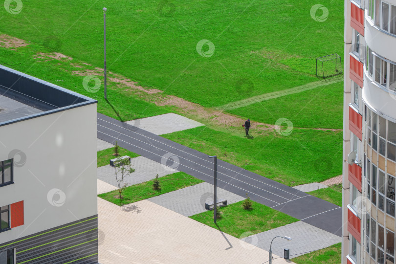 Скачать Новостройка во дворе, муниципальные службы убирают газон. Вид с высоты птичьего полета фотосток Ozero