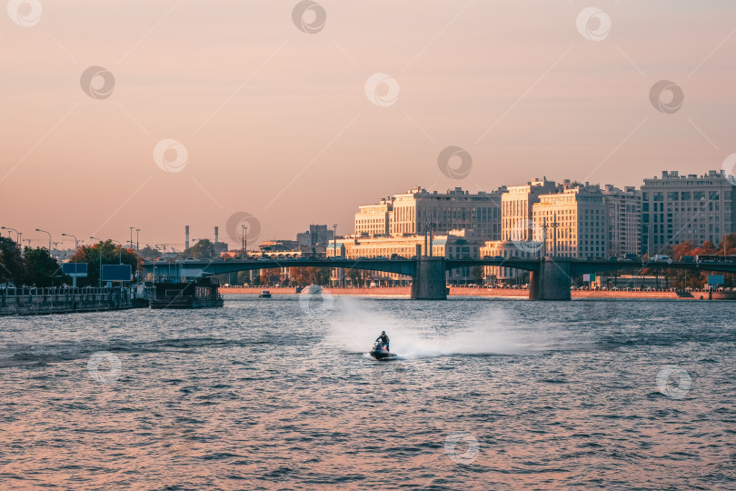 Скачать Мужчина катается на гидроцикле по Неве в центре Санкт-Петербурга. фотосток Ozero