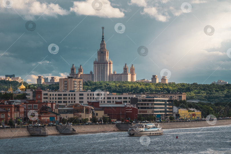 Скачать Прекрасный московский вечерний городской пейзаж. Московский государственный университет на зеленом холме в лучах вечернего солнца. фотосток Ozero