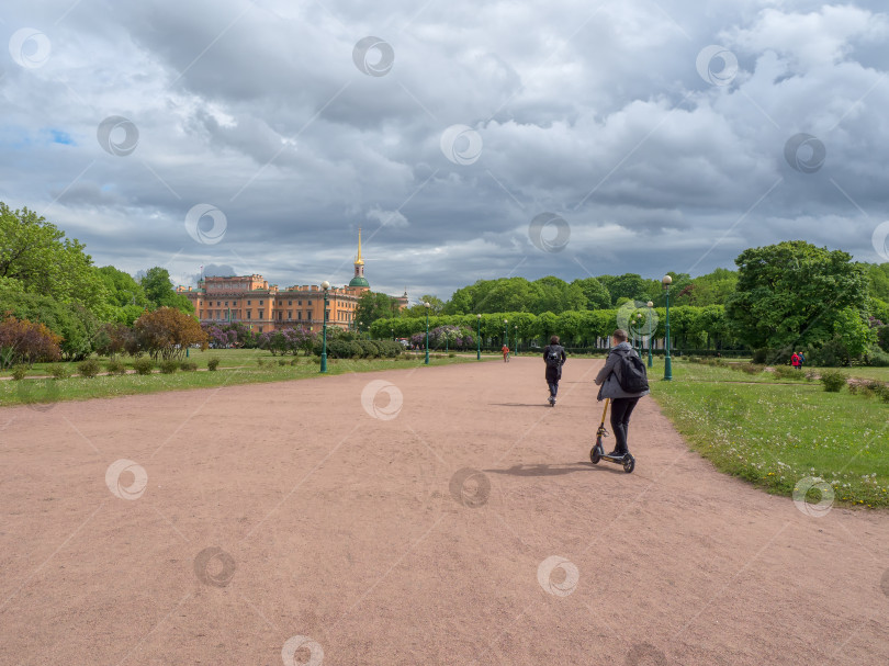 Скачать Подросток катается на скутере в городском парке фотосток Ozero