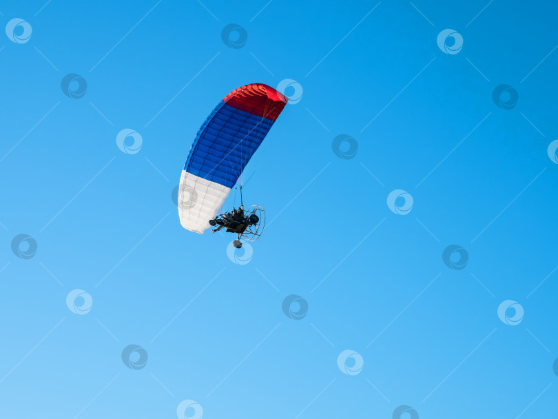 Скачать Приводимый в действие парашют на фоне голубого неба. фотосток Ozero
