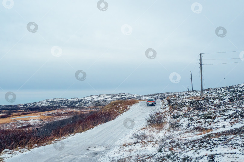 Скачать Зимняя Териберка. Скользкая арктическая дорога через холмы фотосток Ozero