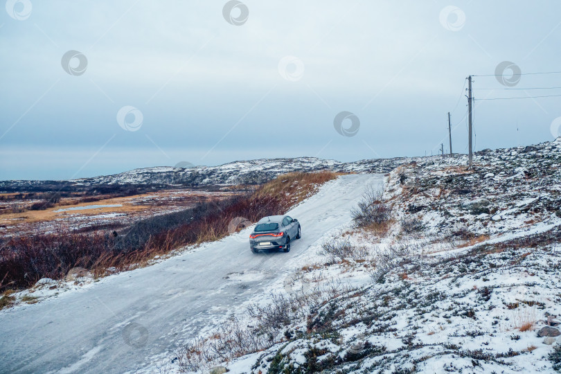 Скачать Скользкая арктическая дорога через холмы. Зимняя Териберка фотосток Ozero