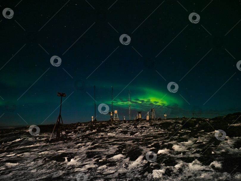 Скачать Старая метеостанция. Ночной зимний полярный пейзаж с северным сиянием. фотосток Ozero