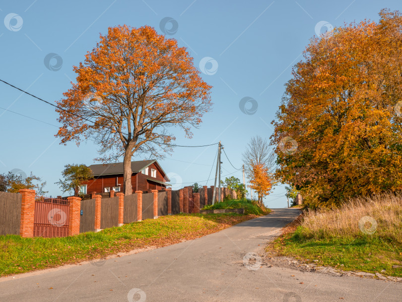 Скачать Пустая деревенская осенняя дорога с домом за забором фотосток Ozero