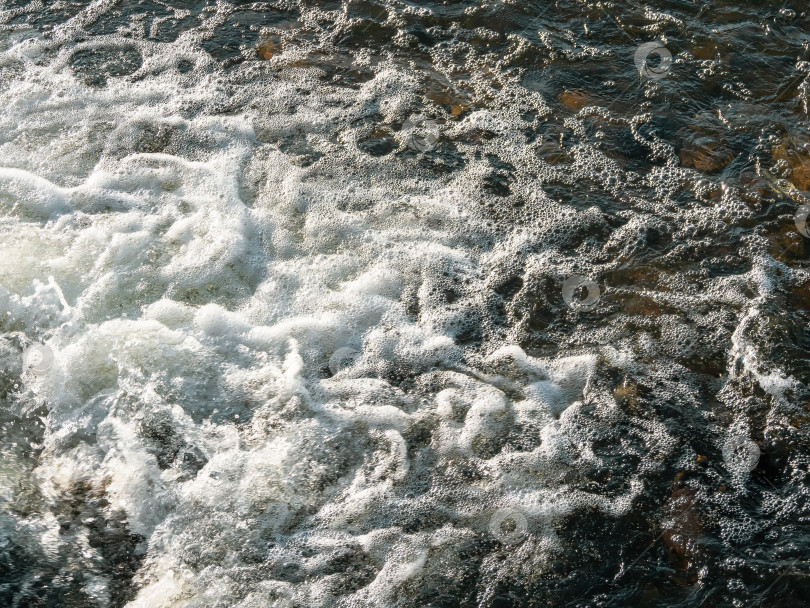 Скачать Струящаяся текстура темной воды. Белая водяная пена, небольшой водоворот, водный фон. фотосток Ozero