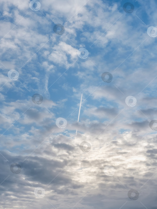 Скачать Реактивный военный самолет летит сквозь облака в голубом небе. Вертикальный вид. фотосток Ozero
