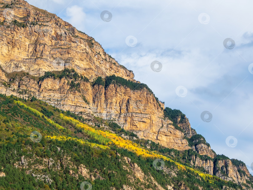 Скачать Красивый горный пейзаж с красными округлыми скалами. Большое скальное образование, различные скальные образования и слои почвы. Далекое горное плато. Северная Осетия. фотосток Ozero