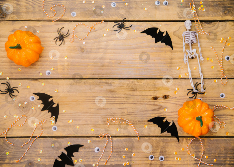 Скачать Тыквы, скелеты, пауки и летучие мыши на деревянном фоне. Праздничная тема Хэллоуина. Пустое место для текста. фотосток Ozero