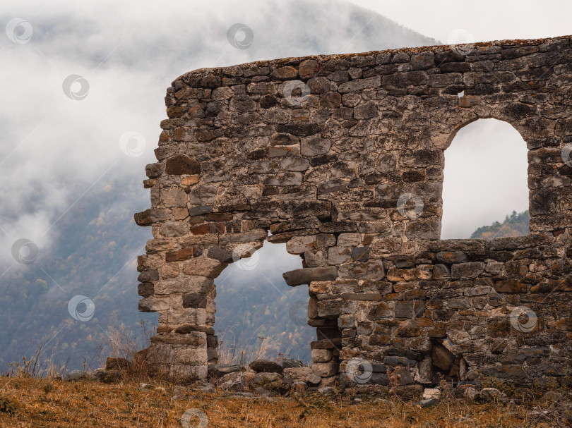Скачать Старая каменная стена с арочным проходом. Комплекс старых эгических башен, одна из крупнейших средневековых башенных деревень замкового типа, расположен на оконечности горного хребта в Ингушетии, Россия. фотосток Ozero