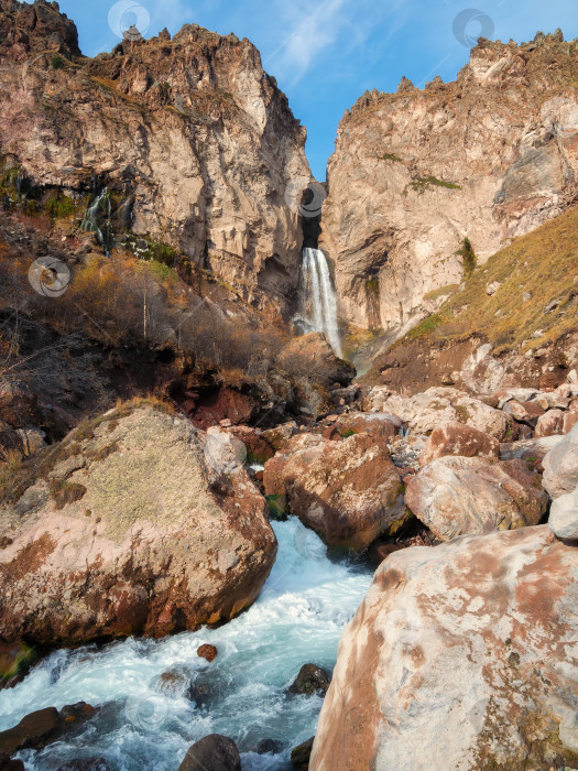 Скачать Удивительный пейзажный вид на большой горный водопад, известный как Султан, осеннюю траву, большие камни и высокие скалы в качестве фона. Природа Кавказа, Приэльбрусье Джила-Су, Кабардино-Балкария. фотосток Ozero