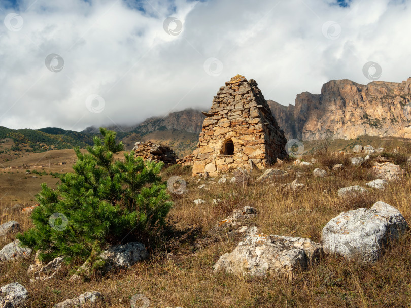 Скачать Старая каменная гробница, склеп на вершине горы. Старинный осетинский фамильный склеп в туманных горах. Россия. фотосток Ozero