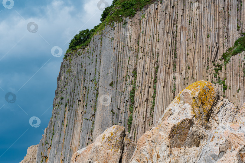 Скачать высокий прибрежный утес, образованный каменными колоннами, мыс Столбчатый на острове Кунашир фотосток Ozero