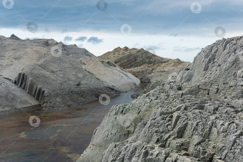 Скачать прибрежные скалы, образованные столбчатым базальтом во время отлива фотосток Ozero