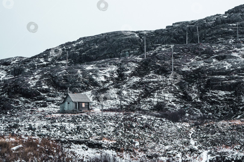 Скачать Заброшенный охотничий домик на заснеженном холме в Арктике. Старинная аутентичная деревня Териберка. фотосток Ozero
