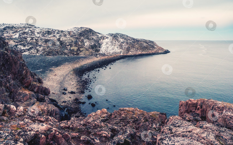 Скачать Скалистый утес над водой с приливной береговой линией. Чудесный панорамный горный пейзаж на берегу Баренцева моря. фотосток Ozero