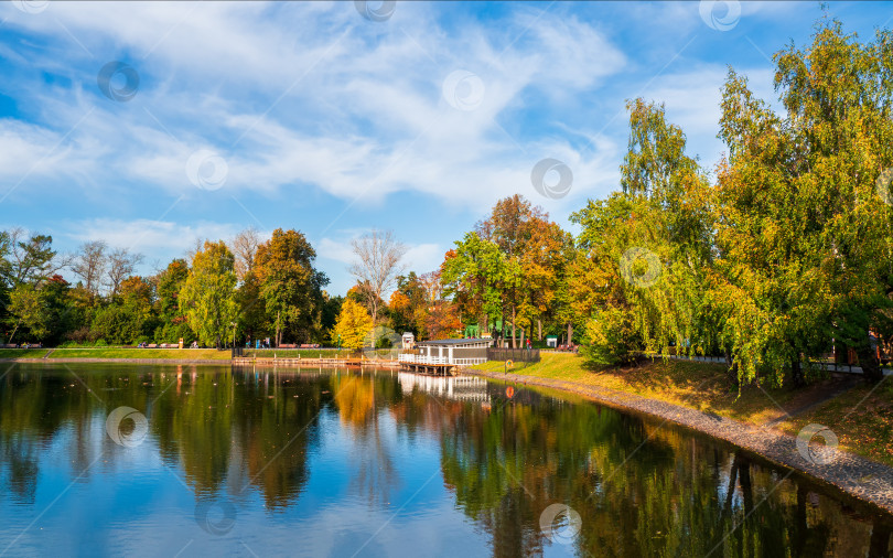Скачать Красивый Останкинский парк в Москве, осенний пруд с пирсом и отражением в воде. фотосток Ozero