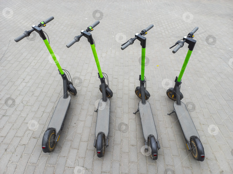 Скачать Два городских скутера на асфальте. Четыре припаркованных скутера в летнем городе. Современный молодежный вид транспорта. фотосток Ozero