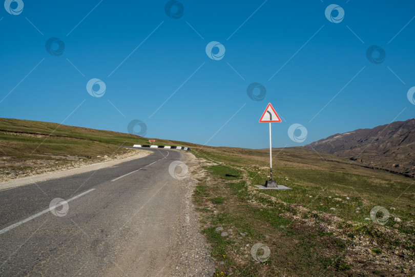 Скачать Пустое шоссе через высокое плато. Дорожный знак. фотосток Ozero