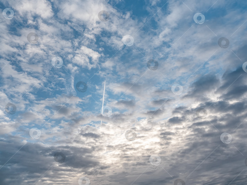 Скачать Облачное небо, белые облака на голубом небе. Реактивный военный самолет летит сквозь облака в голубом небе. фотосток Ozero