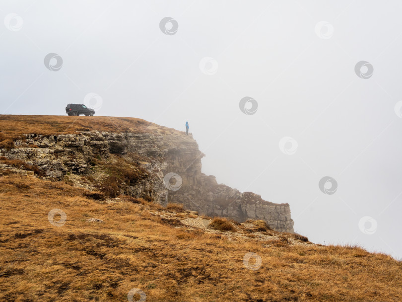 Скачать Внедорожник на краю осеннего крутого обрыва с густой фотосток Ozero