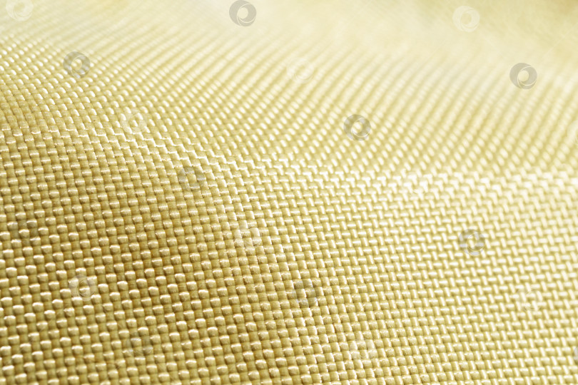 Скачать Пуленепробиваемый материал арамид. Блестящий фон из арамидного кевлара. Текстура и рисунок желтого кевлара. фотосток Ozero