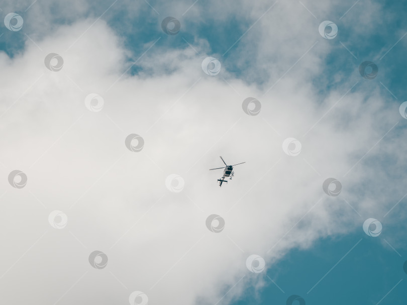 Скачать Маленький вертолет в облачном небе. Частные рейсы, перевозка туристов. фотосток Ozero