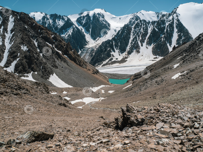 Скачать Прекрасный вид на горное озеро на фоне гор. Атмосферный пейзаж с озером в высокогорной долине. фотосток Ozero
