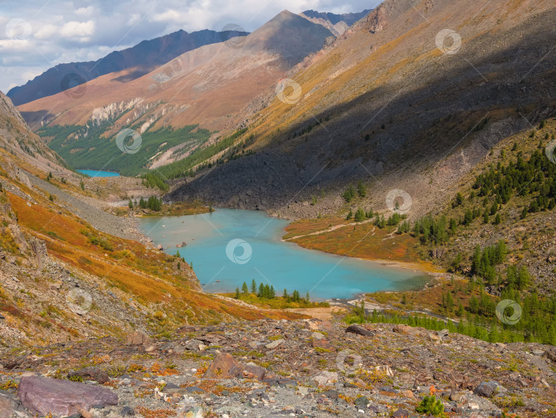 Скачать Прекрасный вид на горное озеро на фоне гор. Атмосферный пейзаж с озером в высокогорной долине. фотосток Ozero