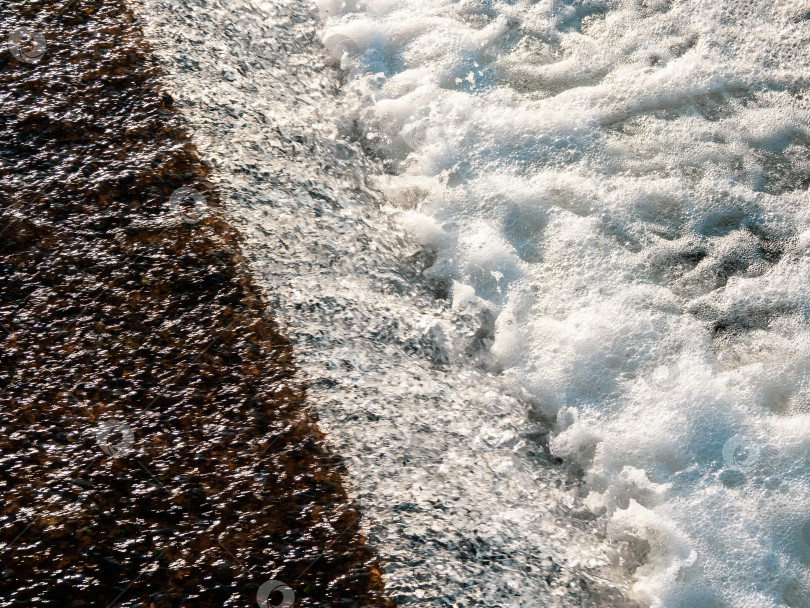 Скачать Текстура струящейся воды. Белая водяная пена, небольшой водопад, водный фон. фотосток Ozero