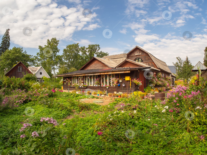 Скачать Деревенский деревянный дом с цветочным садом. Старый деревянный дом. фотосток Ozero