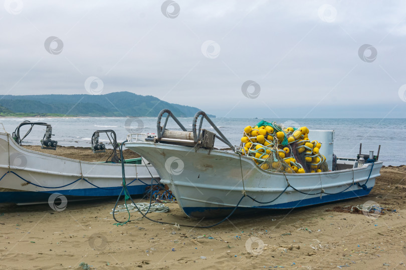 Скачать маленькие рыбацкие лодки с сетью на борту на берегу моря фотосток Ozero
