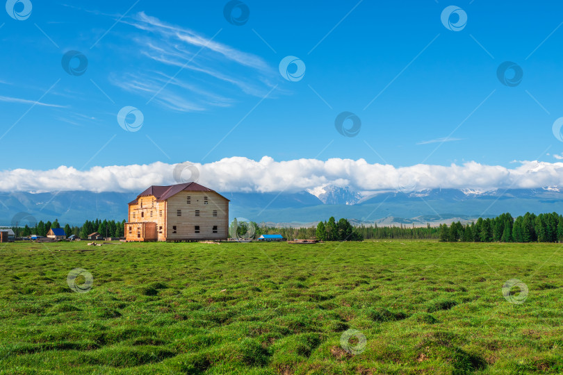 Скачать Туристический комплекс, деревянный гостевой дом на фоне заснеженных высоких гор. фотосток Ozero