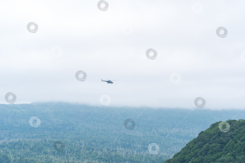 Скачать облачный пейзаж с далеким вертолетом над туманными холмами фотосток Ozero