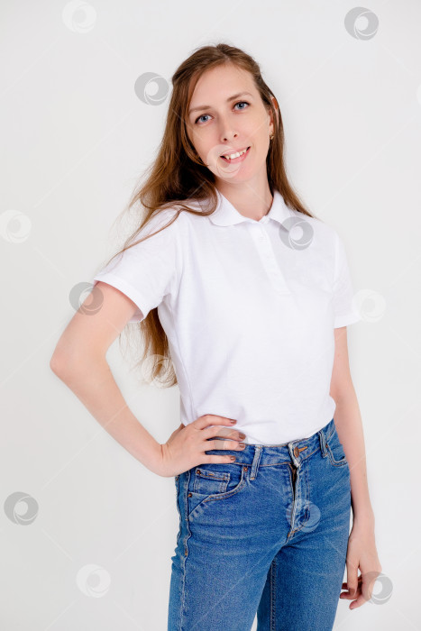 Скачать Милая и улыбчивая девушка в белой футболке радостно улыбается и выражает положительные эмоции на белом фоне. фотосток Ozero