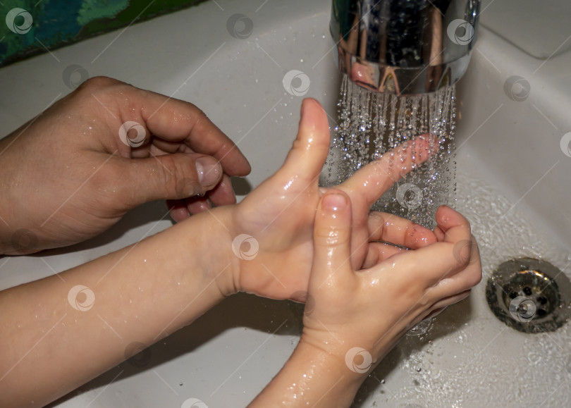 Скачать Крупный план белого мужчины и ребенка, моющих руки в ванной. Профилактика COVID - 19 фотосток Ozero