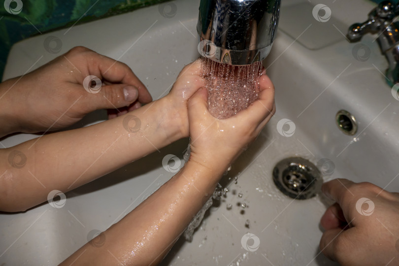 Скачать Крупный план белого мужчины и ребенка, моющих руки в ванной. Профилактика COVID - 19 фотосток Ozero