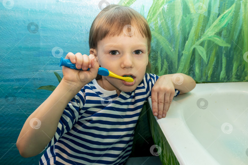Скачать Крупным планом молодой мальчик чистит зубы в кресле стоматолога фотосток Ozero