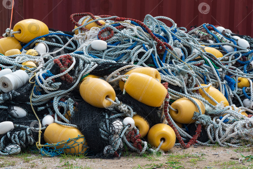 Скачать промышленные рыболовные сети с яркими поплавками сложены на берегу фотосток Ozero