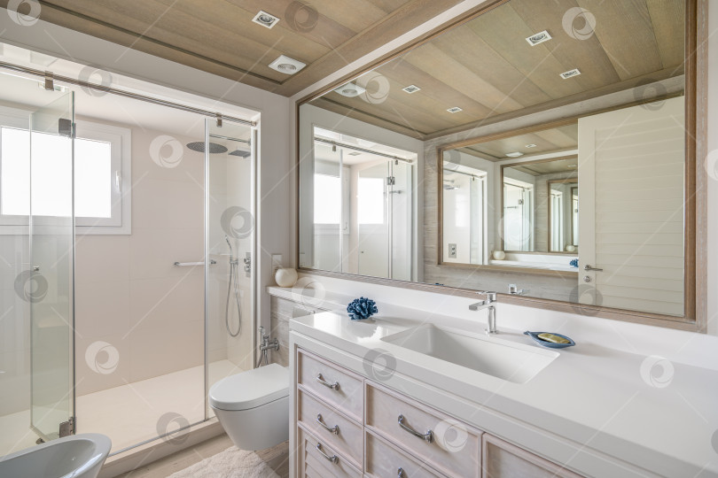 Скачать Роскошная ванная комната с большим зеркалом с необычным многократным отражением. Просторная душевая кабина со стеклянными перилами. Дневной яркий солнечный свет освещает огромную ванную комнату, демонстрируя ее великолепие. фотосток Ozero