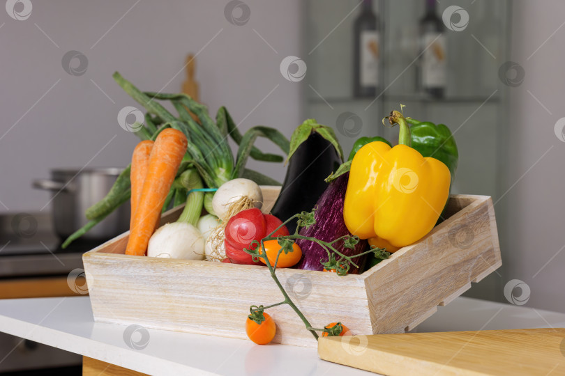 Скачать Деревянная коробка со свежими овощами на подставке фотосток Ozero