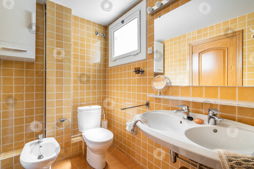 Скачать Интерьер ярко-желтой ванной комнаты с душем, ванной, туалетом и раковиной фотосток Ozero