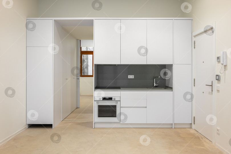 Скачать Белая пустая классическая кухня с видом спереди в новой или отремонтированной квартире фотосток Ozero